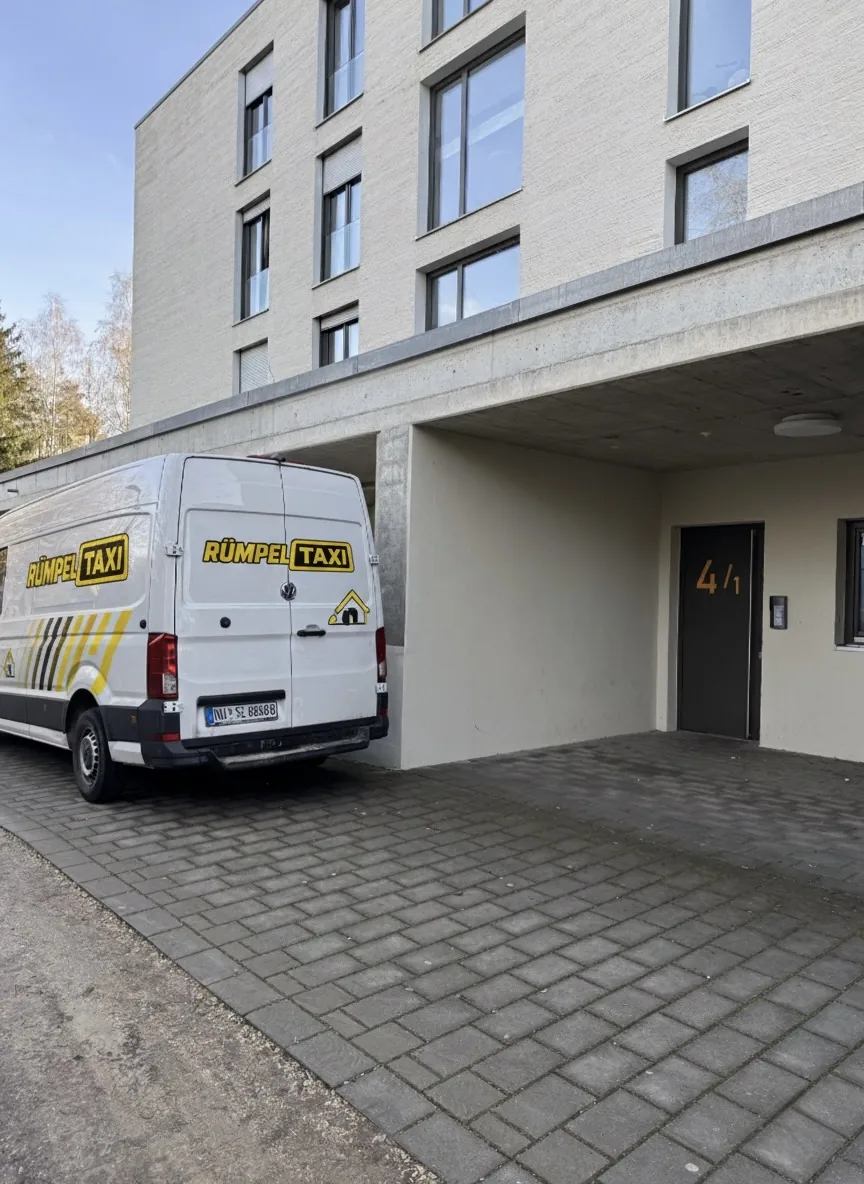 Rümpeltaxi-Transporter im Einsatz vor einem Wohngebäude